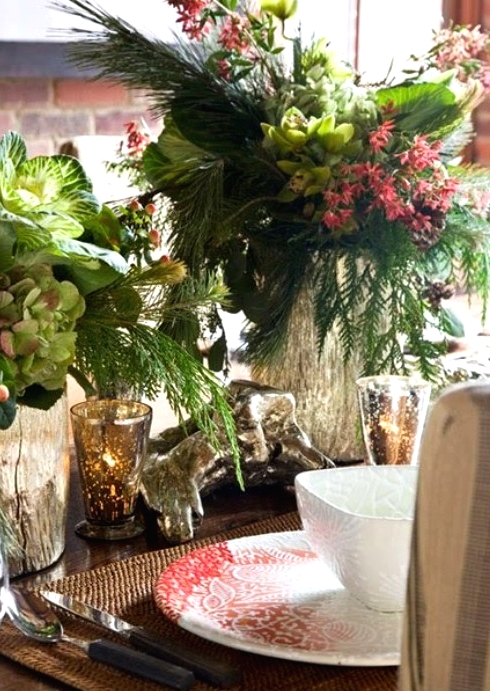 a vintage-inspired Christmas tablescape with woven placemats, printed red and white porcelain, lush greenery and florals, mercury glass candleholders