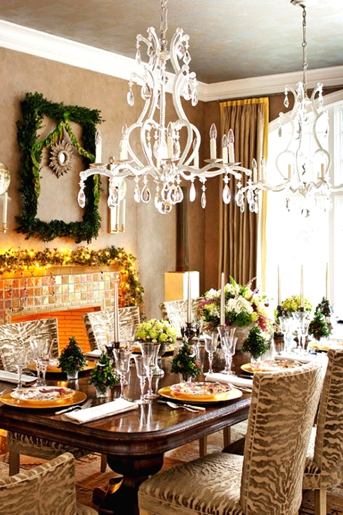 a refined Christmas tablescape with lush floral arrangements, mini Christmas trees, gold placemats and printed plates