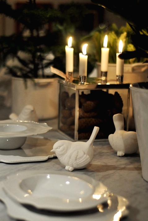 a neutral Christmas tablescape with catchy shaped plates, thin candles, mini Christmas trees and neutral linens