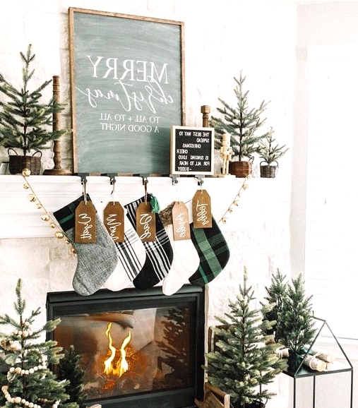 modern farmhouse Christmas decor with plaid stockings, gold bells, mini trees in baskets and crates and a house stand for firewood