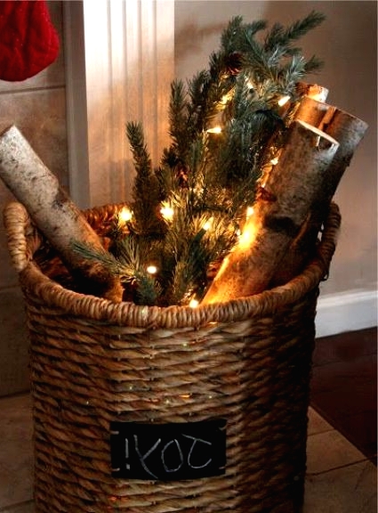 a basket with a chalkboard sign, firewood, evergreens and lights is a pretty rustic decor idea for Christmas, even if you don't have a fireplace