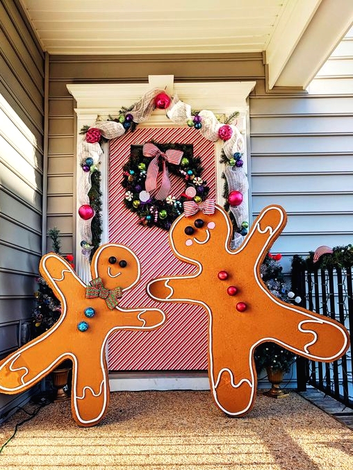 giant gingerbread men with colorful touches make the porch bright and fun and can be DIYed for outdoor Christmas decor