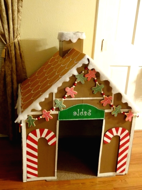 a gingerbread-style dog house of cardboard with candy canes and gingerbread men garlands is a cool idea for the holidays