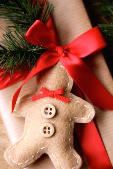 a felt gingerbread man cookie gift tag with a red bow and buttons is a pretty idea for Christmas