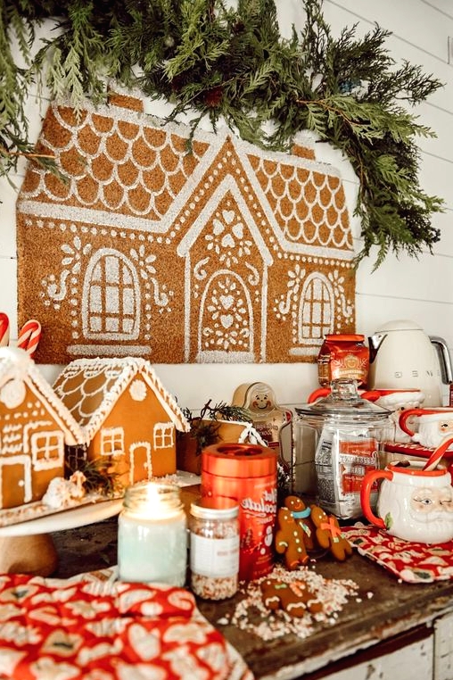 a hot cocoa bar with gingerbread houses, men, cocoa and lots of vintage mugs plus a gingerbread house artwork painted right on the wall