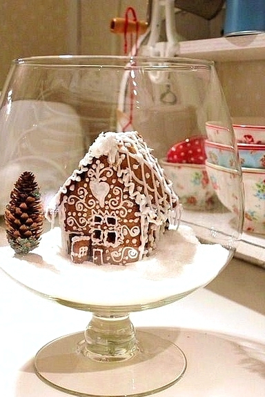 a large glass with faux snow, a pinecone and a glazed gingerbread house is a lovely alternative to a Christmas terrarium