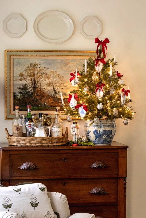 a tabletop Christmas tree decorated with silver and white ornaments, with embroidery hoop ones and red bows is a pretty idea
