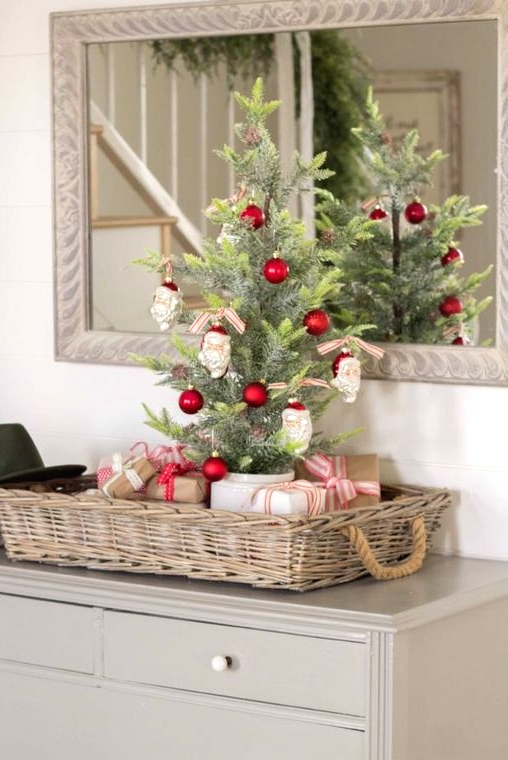 a tabletop Christmas tree decorated with red ornaments and Santa Claus heads is a fun and cool idea with a touch of vintage