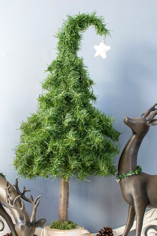 a super creative Christmas tree with a single white star on top and pinecones around is a small take on a traditional tree