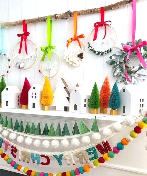 a super cheerful Christmas mantel with colorful bottle brush trees, bold wreaths and bold felt garlands is amazing