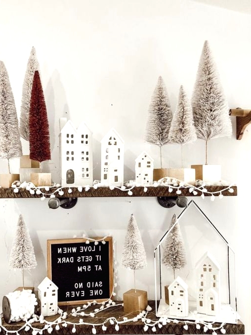 winter shelf styling with small white houses, pompoms, white and red bottle brush Christmas trees