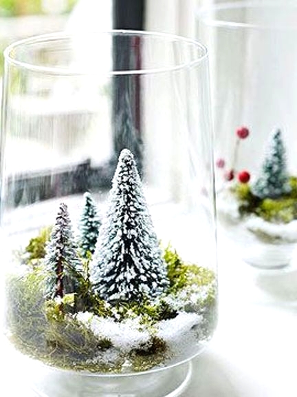 a large glass with moss and small bottle brush trees is a lovely idea of a snow globe with trees