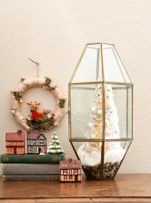 an elegant Christmas terrarium with faux snow, a white bottle brush Christmas tree with pearly ornaments