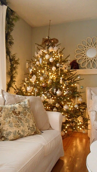 a Christmas tree decorated with white and gold ornaments, lights, snowflakes and snowball ornaments is amazing