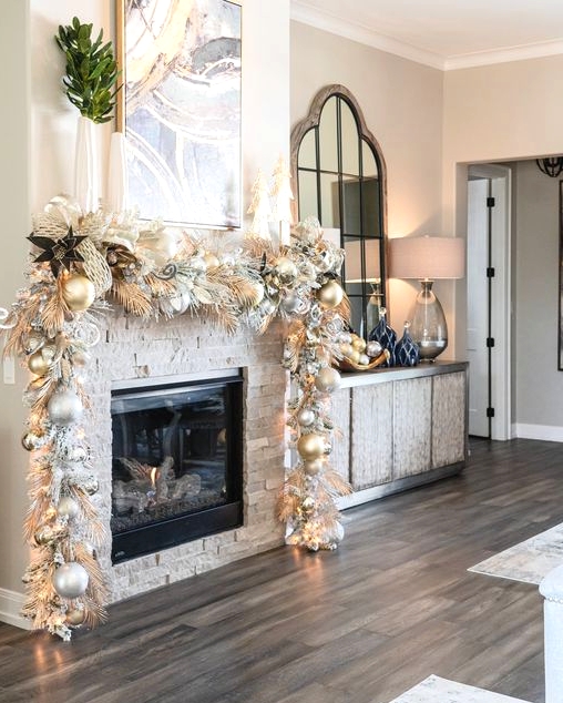 a super glam Christmas mantel garland of white and gold ornaments, white and gold leaves and grasses plus lights