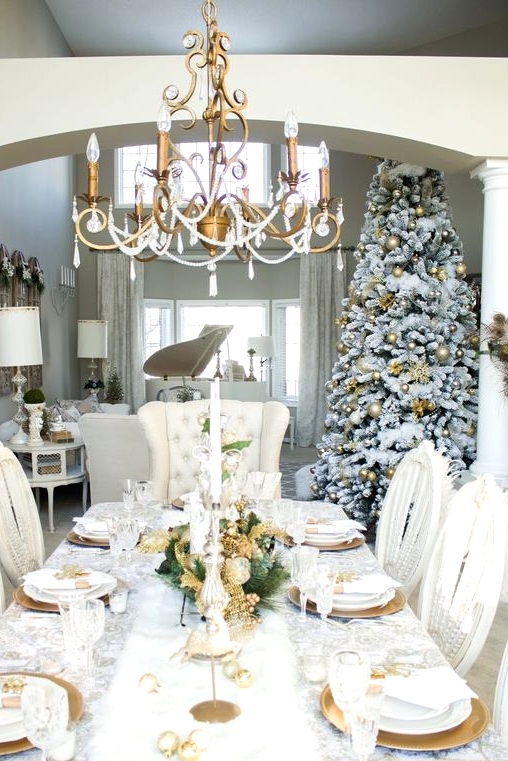 a pretty and bright Christmas tablescape with gold ornaments, leaves, chargers and cutlery, tall and thin candles