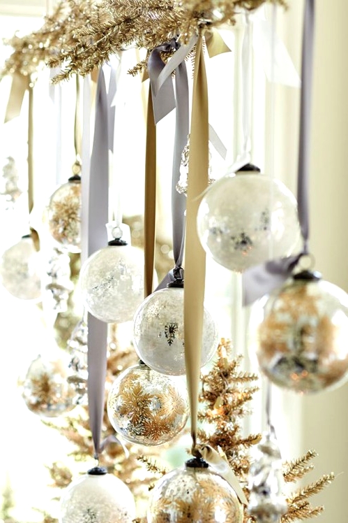 beautiful Christmas decor with a gilded evergreen branch, printed white and gold ornaments hanging on silk ribbons is pure chic and elegance