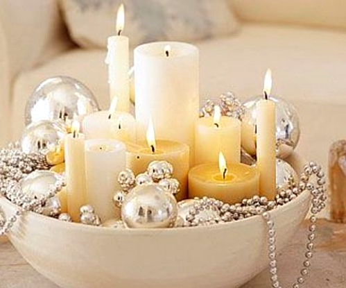a large bowl with pillar and thin candles and gold ornaments and beads is a refined and chic Christmas decoration or centerpiece