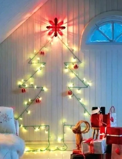 a cute wall-mounted Christmas tree done with green lights and red and white ornaments for a traditional feel