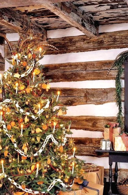 a vintage Christmas tree decorated with lights, citrus slices, stars, cranberry garlands, paper chains and other stuff