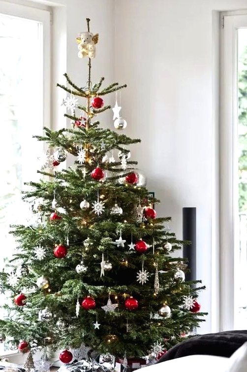 a traditional Christmas tree with white, red, metallic ornaments, balls, snowflakes and stars