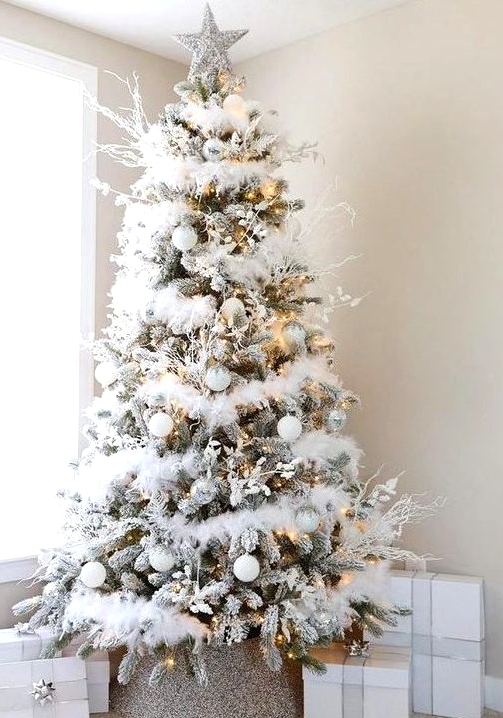 a charming flocked Christmas tree with white faux fur garlands, white and semi sheer ornaments, lights, frosted branches and a silver star topper