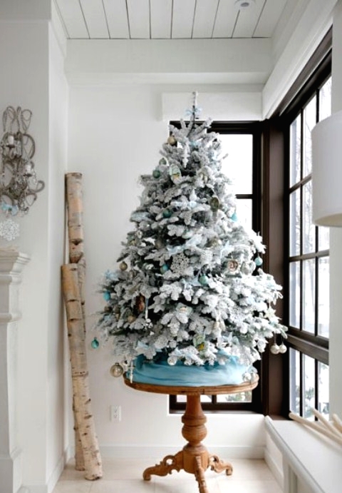 a flocked Christmas tree decorated with aqua, metallic and green ornaments is a beautiful idea for a winter wonderland feel