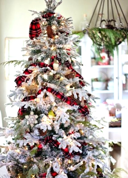 a flocked Christmas tree with metallic and colorful ornaments, red plaid ribbons, pinecones and lights looks very festive and bold