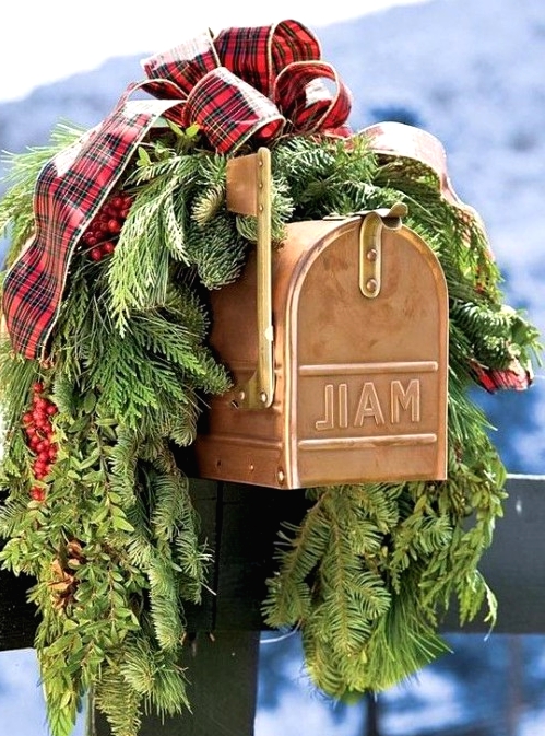 lovely mail box styling with evergreens, red berries and a red plaid bow on top is amazing and very festive-like