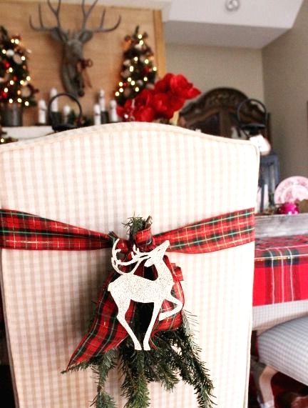 a chair accented with a red plaid ribbon, evergreens and a deer silhouette is a cool and easy way to make your space more Christmassy