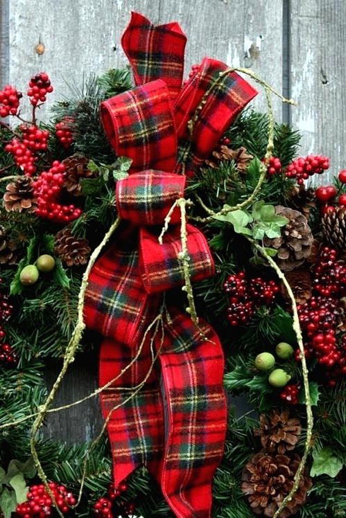 a lush evergreen Christmas with pinecones, berries, greenery and a large plaid bow that screams holidays at once