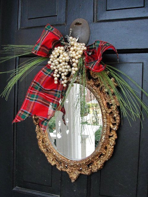 a mirror in an ornated frame, with evergreens, pearls and a red plaid bow is a creative alternative to a usual Christmas wreath
