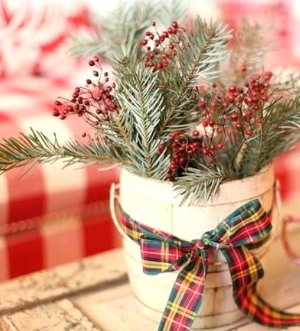 a planter with evergreens and berries and a red and green plaid ribbon is a simple and pretty traditional decoration for holidays