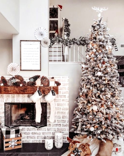 a fabulous winter wonderland Christmas space with oversized pinecones, white stockings, a flocked Christmas tree with lights and pinecones and a toy deer