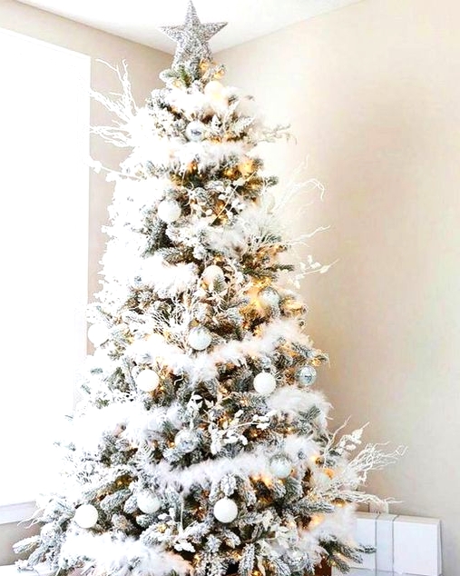a fabulous winter wonderland Christmas tree with white garlands, branches, silver and white ornaments, lights and a silver star topper is wow