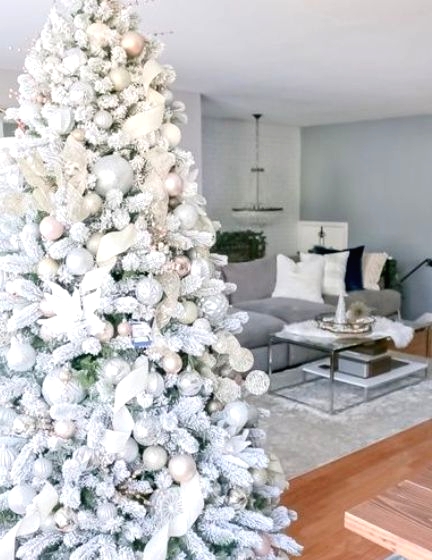 a flocked Christmas tree with pastel and metallic ornaments, white fabric ribbons and fabric blooms is a very fairy-tale like idea