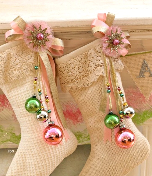 refined vintage neutral stockings with pink and gold brooches and green, gold and pink ornaments on them are amazing Christmassy decor