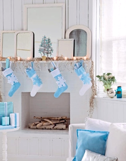 a pretty faux mantel with lights and blue and white stockings with snowflakes to match the decor of the space