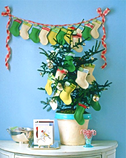 a colorful stocking garland plus a mini potted Christmas tree decorated with matching stockings is a cool idea for a bright and colorful holiday space
