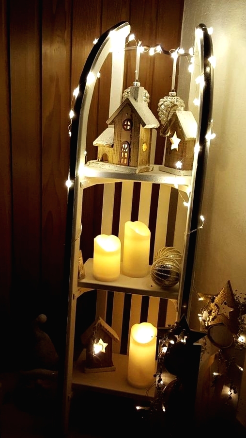 a vintage sleigh with wooden houses, lights, pillar candles and oversized Christmas ornaments is a great Christmas decoration for both indoors and outdoors