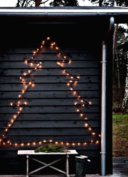 a Christmas tree of lights attached to the wall is a cool outdoor decoration you may rock at holidays