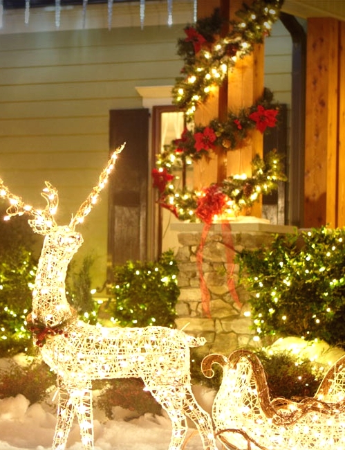 a deer with a sleigh composed of lights, an evergreen and light garland covering the pillar are amazing for creating a Christmas scene