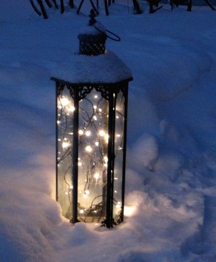 a lantern with lights placed right into the snow will give your space a gorgeous winter wonderland feel