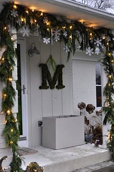 an evergreen and light garland, snowflakes and icicles make the porch very holiday-like and give it a fresh feel