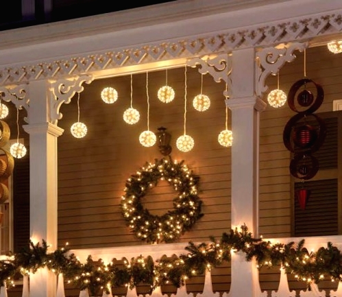 an evergreen and light garland, an evergreen and light wreath, hanging bulbs give a strong Christmas feel to the space