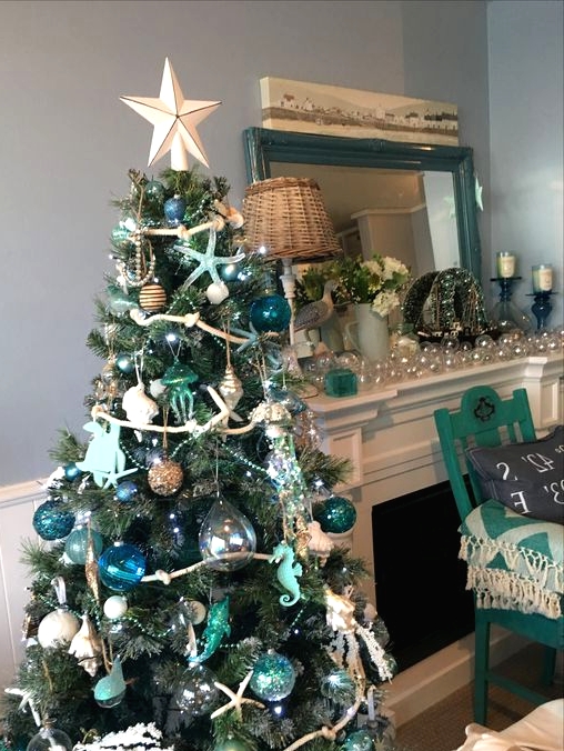 a beach Christmas tree with glass buoy, dolphin, starfish ornaments, green and blue ones, a star tree topper is a cool idea