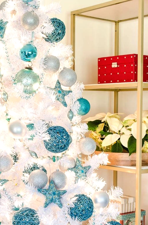a beautiful beach Christmas tree with white, silver and turquoise ornaments and beads is a gorgeous idea for a coastal Christmas space