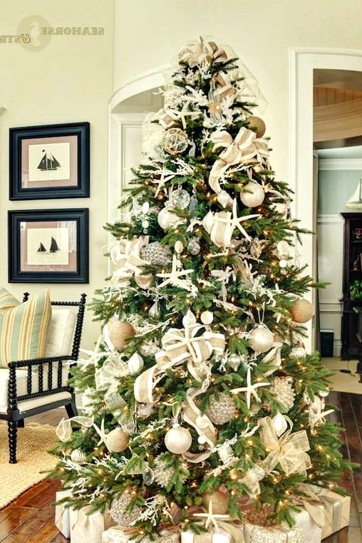a coastal Christmas tree with starfish, seashells, neutral and metallic ornaments, lights and burlap ribbons