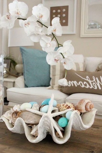 an oversized seashell with neutral and light blue ornaments, seashells and starfish is a lovely decoration for a beach Christmas party