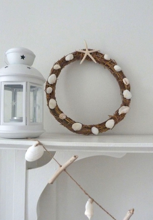 a beach Christmas wreath of vine, with seashells and starfish plus a driftwood and seashell garland will style your mantel for Christmas right